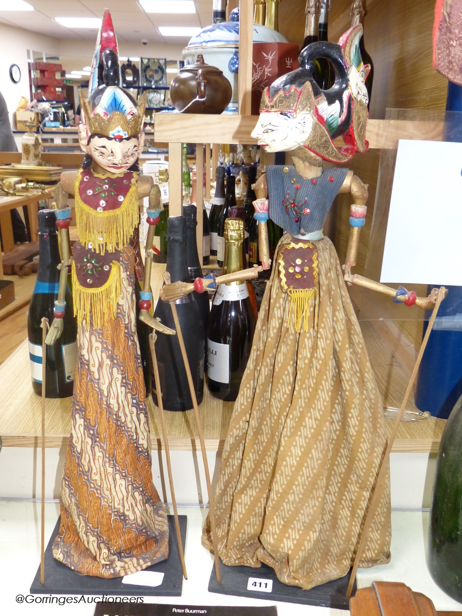 Two Indonesian stick puppets and a book relating to stick puppets, tallest 70cm